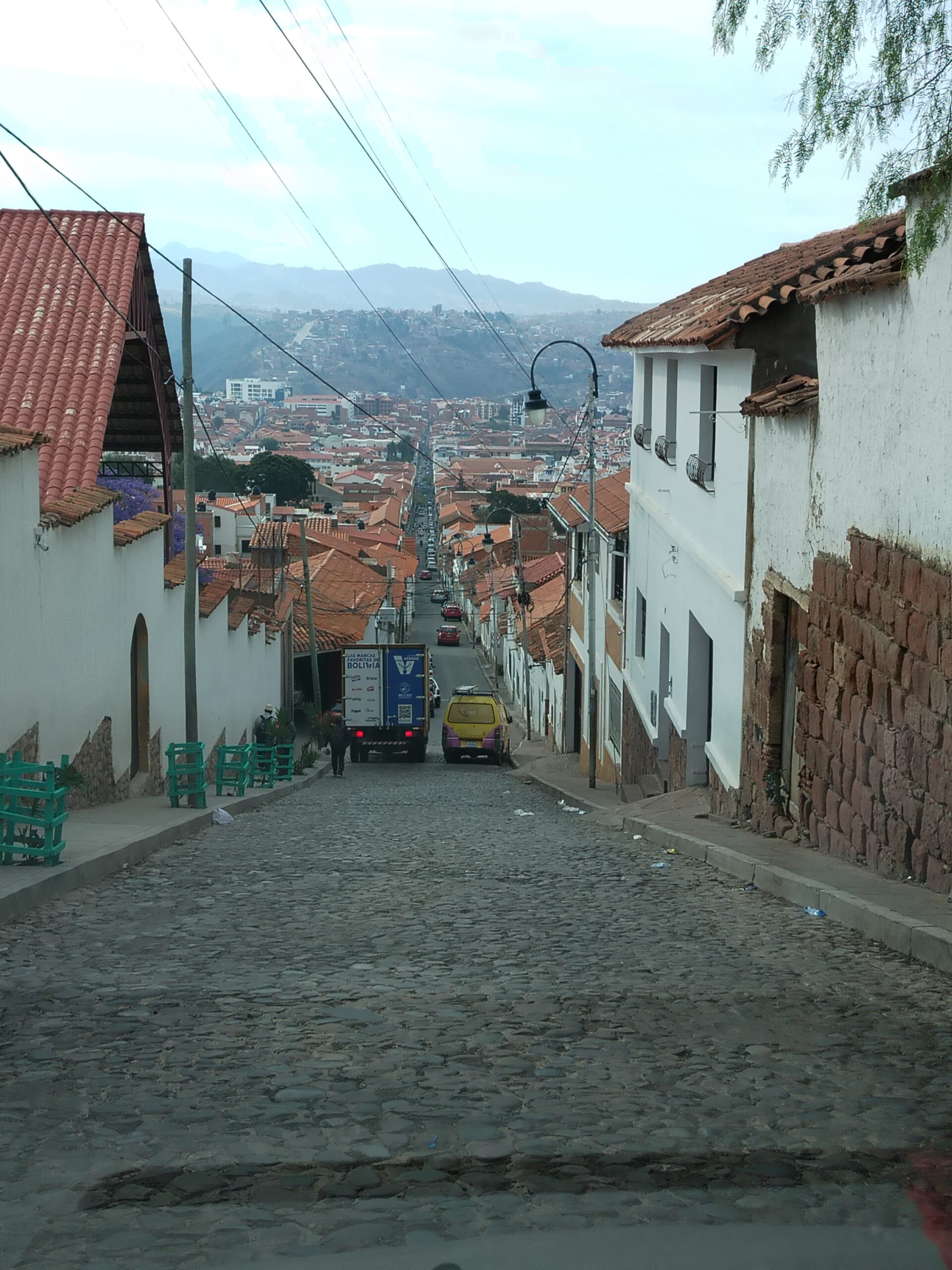 Calle empinada de piedra que baja desde Recoleta con la vista de Sucre al fondo