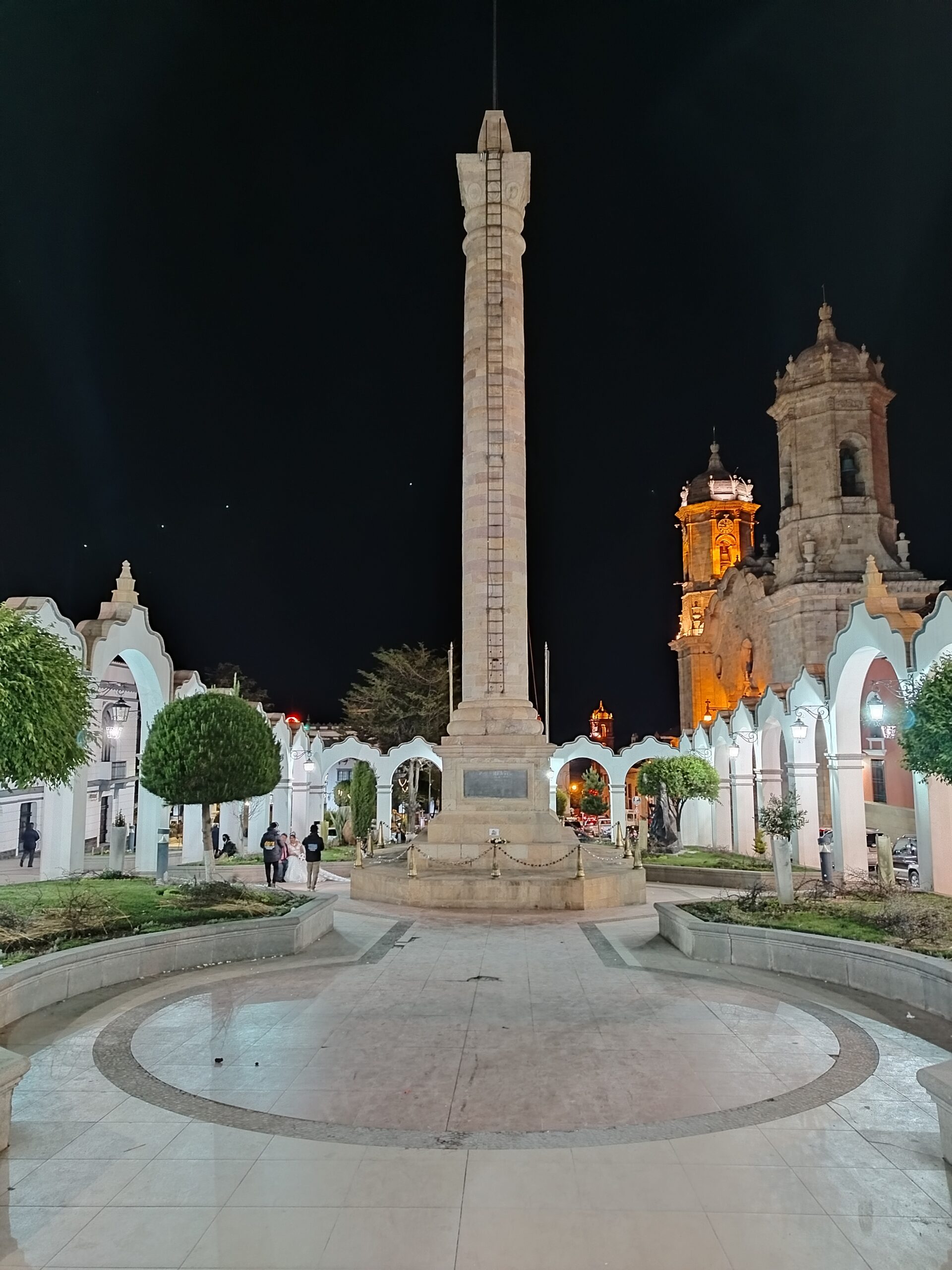 Columna conmemorativa en el centro de Potosí y la torre de la iglesia al fondo